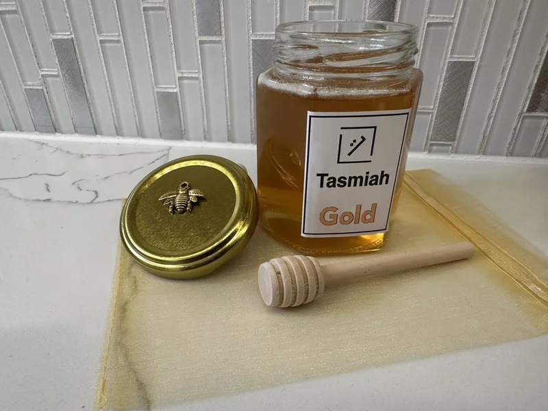 Unpacked jar of Tasmiah Gold honey with dipper